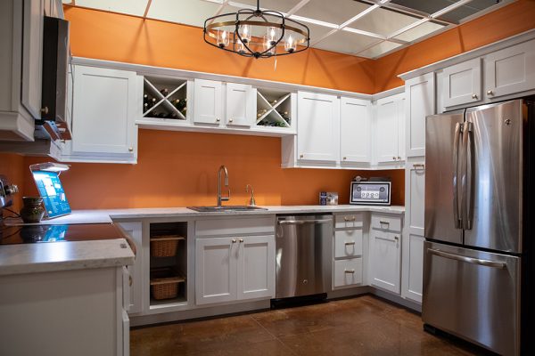 Kitchen with orange walls and white cabinets